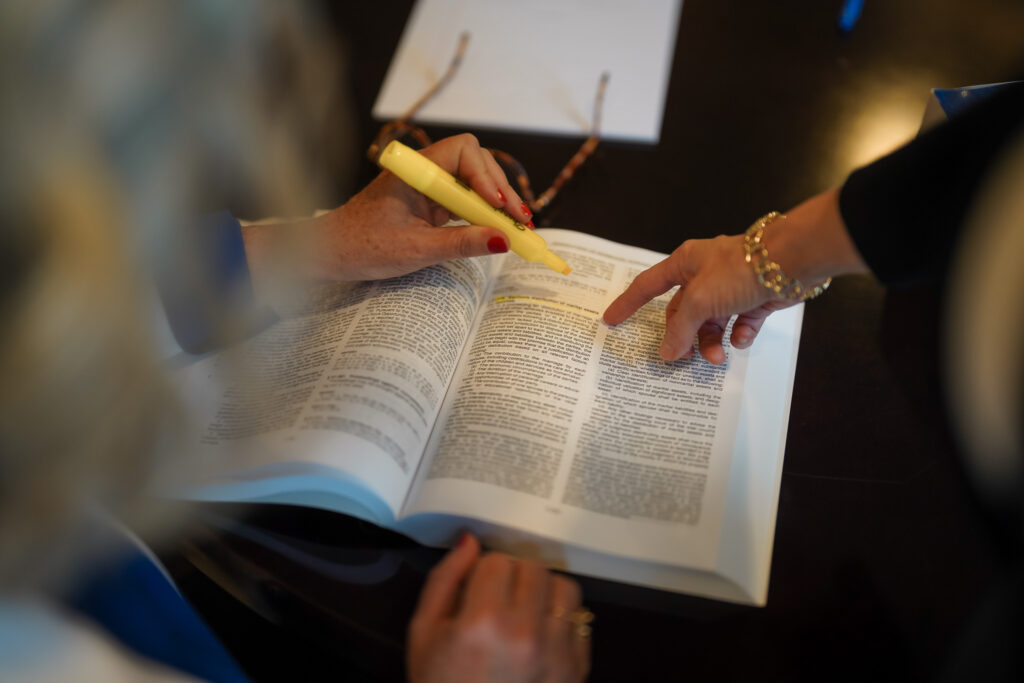 Photo of Shannon Novey and Christin Gonzalez reading a book together for Novey+Gonzalez Family Law.